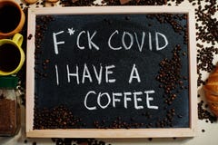 Fuck Covid i have a coffee. Words on blackboard flat lay