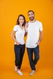 Full length photo of beautiful couple smilings while standing, isolated over yellow background royalty free stock photo Full length photo of beautiful couple smilings while standing, isolated over yellow background royalty free stock photo