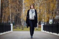 Full-length photo of brunette in black coat in autumn park