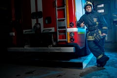 Full-length photo of man firefighter at fire truck