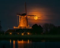 The full moon shines through the sails of the Lion windmill in Anna Paulowna. The full moon rises behind the Anna Paulowna