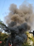 Fumo nero che esce da una costruzione sul fuoco immagini stock Fumo nero che esce da una costruzione sul fuoco immagini stock