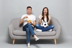 Fun couple woman man football fans cheer up support favorite team with soccer ball, hold glass bowl of chips, depicting royalty free stock image Fun couple woman man football fans cheer up support favorite team with soccer ball, hold glass bowl of chips, depicting royalty free stock image
