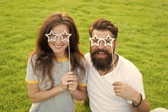 Fun props. Funny couple holding star-shaped photobooth props on sticks. Happy family celebrating with party props