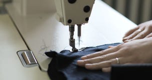Funcionamento da mulher como o desenhador de moda com a máquina de costura no estúdio filme Funcionamento da mulher como o desenhador de moda com a máquina de costura no estúdio filme