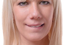 Fundersam blond kvinna som biter hennes kant Arkivfoto Fundersam blond kvinna som biter hennes kant Arkivfoto