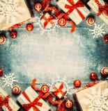 Fundo do Natal com caixas de presente, as decorações festivas vermelhas do feriado e os flocos de neve de papel fotos de stock Fundo do Natal com caixas de presente, as decorações festivas vermelhas do feriado e os flocos de neve de papel fotos de stock