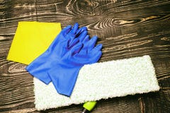 fundo, espanador e luvas de madeira escuros há um raspador para vidros e produtos de limpeza há um tanirovanie imagens de stock royalty free fundo, espanador e luvas de madeira escuros há um raspador para vidros e produtos de limpeza há um tanirovanie imagens de stock royalty free