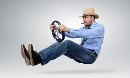 Funny bearded man in a hat and cigar driver car with a wheel Stock Image Funny bearded man in a hat and cigar driver car with a wheel Stock Image