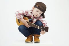 Funny child boy with guitar.ukulele guitar. fashionable country boy playing music