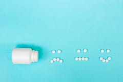 Funny faces made of pills and a plastic bottle on a blue background. The concept of antidepressants and healing. Copy royalty free stock images Funny faces made of pills and a plastic bottle on a blue background. The concept of antidepressants and healing. Copy royalty free stock images