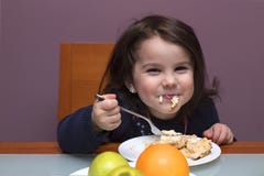 funny little girl eating. She is sitting at the table royalty free stock photo funny little girl eating. She is sitting at the table royalty free stock photo
