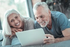 Satisfied lovely couple laughing and using the tablet. royalty free stock photography Satisfied lovely couple laughing and using the tablet. royalty free stock photography