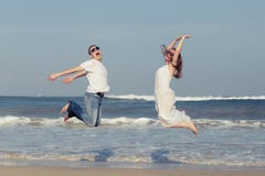 Funzionamento amoroso delle coppie sulla spiaggia al tempo di giorno immagine stock Funzionamento amoroso delle coppie sulla spiaggia al tempo di giorno immagine stock
