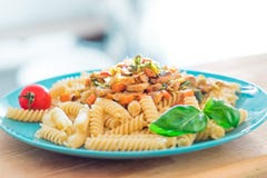 Fusilli cucinato della pasta con i funghi e le verdure fritti sul piatto del turchese fotografia stock libera da diritti Fusilli cucinato della pasta con i funghi e le verdure fritti sul piatto del turchese fotografia stock libera da diritti
