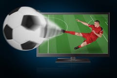 Futbolista apto que juega y que golpea la bola con el pie de la TV imagen de archivo libre de regalías Futbolista apto que juega y que golpea la bola con el pie de la TV imagen de archivo libre de regalías