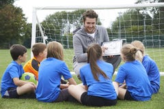 Fußball-Team Trainer-Giving Team Talk To Elementary School lizenzfreies stockfoto Fußball-Team Trainer-Giving Team Talk To Elementary School lizenzfreies stockfoto