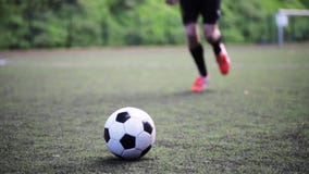 Fußballspieler, der mit Ball auf Feld spielt Fußballspieler, der mit Ball auf Feld spielt