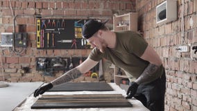 Fähigkeit bärtige craftman Funktionsstellung am Tisch in der Garage Ein Mann arbeitet in einer Werkstatt Das Brett mit den Werkze stock video footage Fähigkeit bärtige craftman Funktionsstellung am Tisch in der Garage Ein Mann arbeitet in einer Werkstatt Das Brett mit den Werkze stock video footage