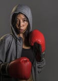 Färdigt barn och sund asiatisk koreansk boxarekvinna i handskar för för konditionöverkanthoodie som och boxning poserar kalla den royaltyfria bilder Färdigt barn och sund asiatisk koreansk boxarekvinna i handskar för för konditionöverkanthoodie som och boxning poserar kalla den royaltyfria bilder