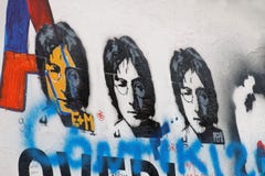 Färgrik grafittivägg, tre kopior av Lennon arkivfoton Färgrik grafittivägg, tre kopior av Lennon arkivfoton