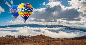 Färgrika hot-air ballonger som flyger över berg Konstnärlig pict royaltyfri bild Färgrika hot-air ballonger som flyger över berg Konstnärlig pict royaltyfri bild