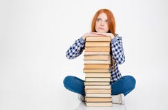 A fêmea pensativa pôs a cabeça sobre a pilha de livros imagem de stock royalty free A fêmea pensativa pôs a cabeça sobre a pilha de livros imagem de stock royalty free
