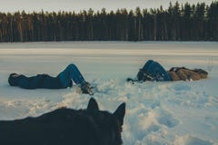 För flickor som ligger i den hållande ögonen på hunden för snö fotografering för bildbyråer För flickor som ligger i den hållande ögonen på hunden för snö fotografering för bildbyråer