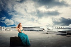 För flygavvikelse för kvinna väntande sammanträde på resväskan som talar på telefonen royaltyfria bilder För flygavvikelse för kvinna väntande sammanträde på resväskan som talar på telefonen royaltyfria bilder