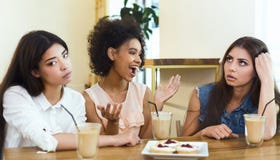 F?rarga den snacksaliga v?nnen som sitter i kaf? med flickor arkivbild F?rarga den snacksaliga v?nnen som sitter i kaf? med flickor arkivbild