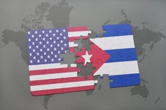 Förbrylla med nationsflaggan av USA och Kuba på en världskartabakgrund royaltyfri foto Förbrylla med nationsflaggan av USA och Kuba på en världskartabakgrund royaltyfri foto