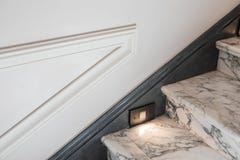Föreningspunkten av stenmoment med inbyggd belysning, paneler och vita väggar med stöpningar arkivbilder Föreningspunkten av stenmoment med inbyggd belysning, paneler och vita väggar med stöpningar arkivbilder