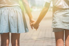 Förtjusande familjbegrepp: Två systrar som går på gångbanan på offentligt, parkerar och tillsammans rymmer handen royaltyfria bilder Förtjusande familjbegrepp: Två systrar som går på gångbanan på offentligt, parkerar och tillsammans rymmer handen royaltyfria bilder