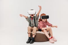 förtjusande små barn som spelar i virtuell verklighethörlurar med mikrofon royaltyfri foto förtjusande små barn som spelar i virtuell verklighethörlurar med mikrofon royaltyfri foto