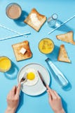 Förvanskade ägg, bredde smör på rostade bröd och drinkar på en blå tabell Bästa sikt för frukost arkivfoton Förvanskade ägg, bredde smör på rostade bröd och drinkar på en blå tabell Bästa sikt för frukost arkivfoton