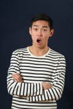 Förvånad ung asiatisk man med korsade händer royaltyfri foto Förvånad ung asiatisk man med korsade händer royaltyfri foto