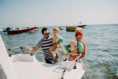Föräldrar med två lilla litet barnbarn som står med fartyget på sommarferie fotografering för bildbyråer Föräldrar med två lilla litet barnbarn som står med fartyget på sommarferie fotografering för bildbyråer