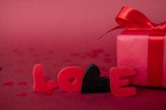 Förälskelseord med den röda gåvaasken på röd bakgrund Fostra ` s, kvinna` s, bröllop, det lyckliga begreppet för st-valentindagen arkivfoto Förälskelseord med den röda gåvaasken på röd bakgrund Fostra ` s, kvinna` s, bröllop, det lyckliga begreppet för st-valentindagen arkivfoto