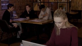 Für Laptop im Café junge lernt eine Frau und arbeitet unter Leuten stock video footage Für Laptop im Café junge lernt eine Frau und arbeitet unter Leuten stock video footage