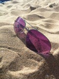 Gafas de sol en la arena de la playa fotos de archivo Gafas de sol en la arena de la playa fotos de archivo