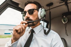 Gafas de sol que llevan del piloto confiado mientras que lo sienta la cabina fotografía de archivo Gafas de sol que llevan del piloto confiado mientras que lo sienta la cabina fotografía de archivo