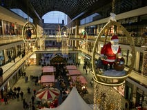 Gallerian av Berlin dekorerade för jul med en stora träSanta Claus, upptaget med många shoppare royaltyfri bild Gallerian av Berlin dekorerade för jul med en stora träSanta Claus, upptaget med många shoppare royaltyfri bild