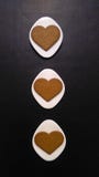 Galletas en forma de corazón en los platillos Rhombus-formados blancos y el fondo negro fotografía de archivo Galletas en forma de corazón en los platillos Rhombus-formados blancos y el fondo negro fotografía de archivo