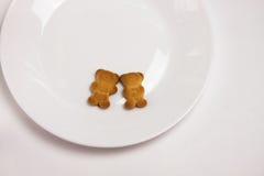 Galletas lindas de los osos en la placa redonda de cer?mica en el fondo blanco Visi?n desde arriba, endecha plana fotografía de archivo Galletas lindas de los osos en la placa redonda de cer?mica en el fondo blanco Visi?n desde arriba, endecha plana fotografía de archivo