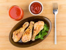 Gambe di pollo fritto in piatto, succo di pomodoro e salsa neri Immagini Stock Gambe di pollo fritto in piatto, succo di pomodoro e salsa neri Immagini Stock