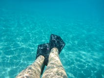 Gambe femminili con la vista subacquea delle alette di bella spiaggia di Skala dell'isola di Kefalonia, mare ionico, Grecia immagini stock libere da diritti Gambe femminili con la vista subacquea delle alette di bella spiaggia di Skala dell'isola di Kefalonia, mare ionico, Grecia immagini stock libere da diritti