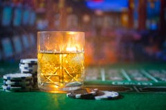 gambling, fortune, game and entertainment concept - close up of casino chips and whisky glass on table stock image gambling, fortune, game and entertainment concept - close up of casino chips and whisky glass on table stock image