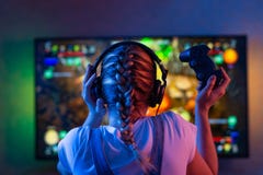Gamer или девушка ленты дома в темной комнате с gamepad играя с друзьями на сетях в видеоиграх Молодой человек стоковое фото rf Gamer или девушка ленты дома в темной комнате с gamepad играя с друзьями на сетях в видеоиграх Молодой человек стоковое фото rf
