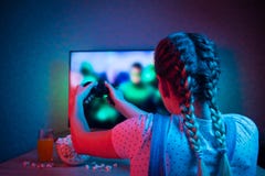 Gamer или девушка ленты дома в темной комнате с gamepad, играя с друзьями онлайн в видеоиграх с попкорном и мульти- стоковые изображения rf Gamer или девушка ленты дома в темной комнате с gamepad, играя с друзьями онлайн в видеоиграх с попкорном и мульти- стоковые изображения rf
