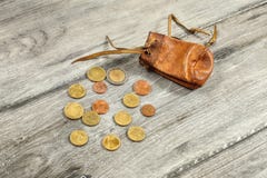 Gammal sliten brun lädermyntpåse, med euromynt som spills på G royaltyfri foto Gammal sliten brun lädermyntpåse, med euromynt som spills på G royaltyfri foto